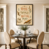 Bake the World a Better Place framed printable wall art displayed above a dining table in an elegant neutral kitchen and dining room interior.